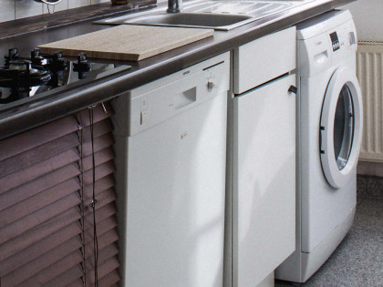 A washer sits in the far right next to a dish washer. If you need to get rid of these items, DIY offers large item disposal.