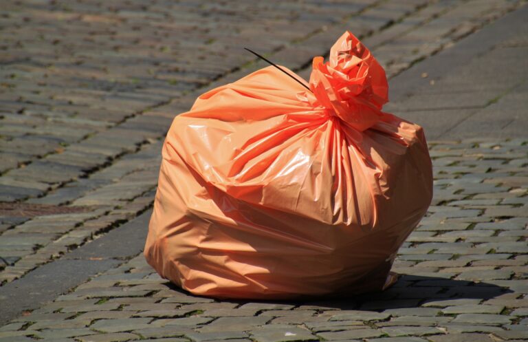 An orange garbage bag filled with garbage